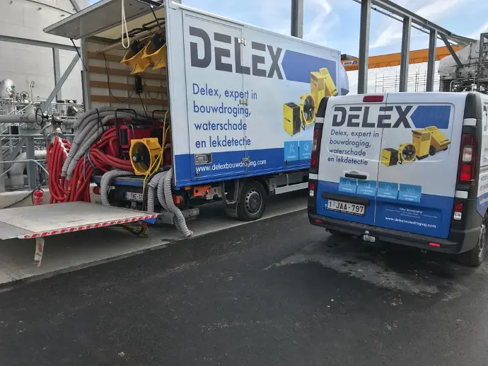 2 bestelwagens van Delex tijdens een project waar Delex een droogpoject op maat uitvoert op vraag van de klant.